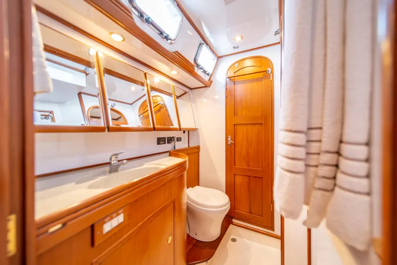 Slide: The Image of Luxurious wooden bathroom interior on a 2010 Hylas 70 yacht, featuring elegant fixtures. - 37