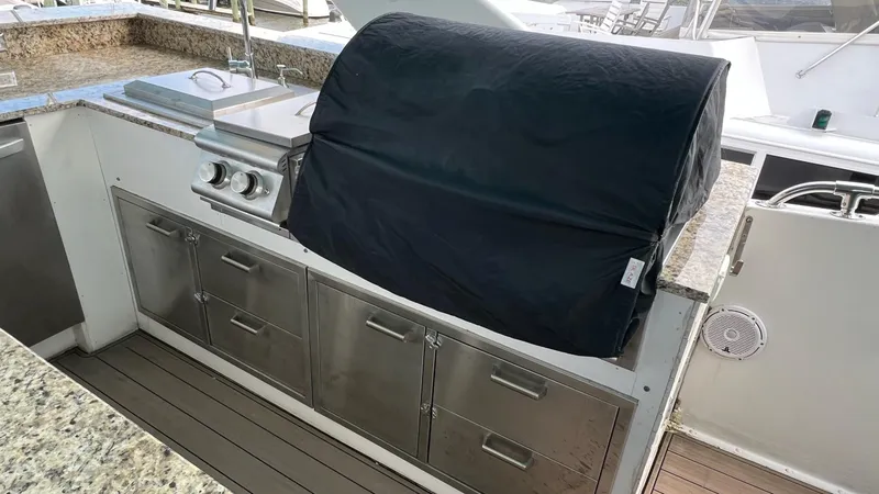Slide: The Image of Outdoor kitchen on 1987 Hatteras Motoryacht with covered grill and stainless steel cabinets. - 12