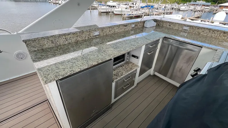Slide: The Image of 1987 Hatteras Motoryacht kitchen with granite countertops and stainless steel appliances, dockside view. - 13