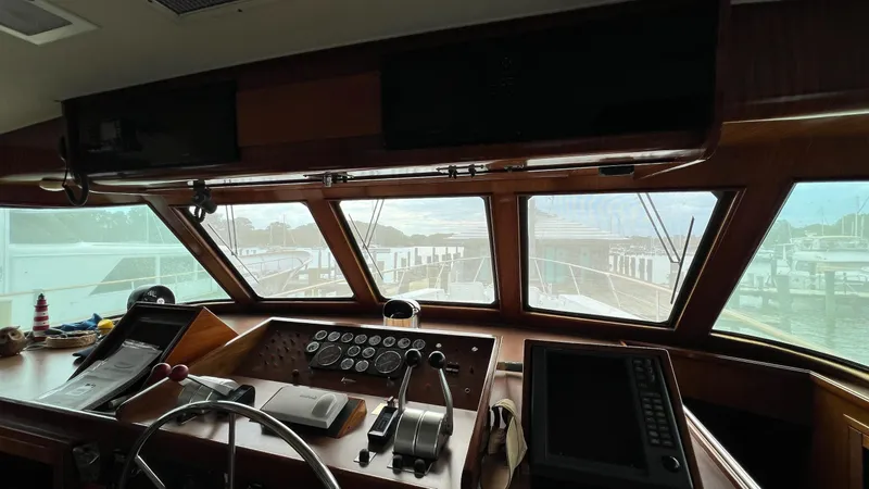 Slide: The Image of 1987 Hatteras Motoryacht helm with navigation instruments and marina view through windows. - 17