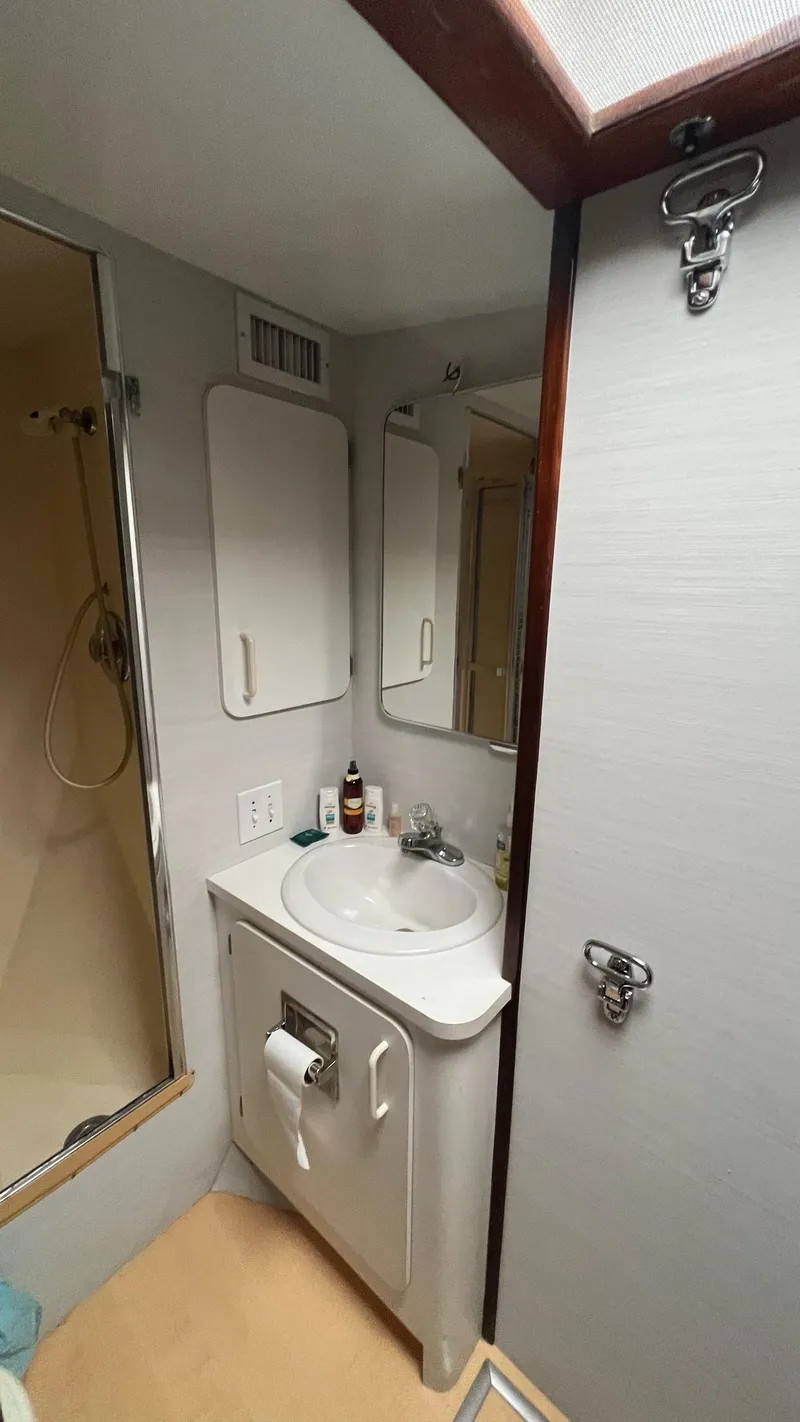 Slide: The Image of 1987 Hatteras Motoryacht bathroom with sink, mirror, and shower. - 23