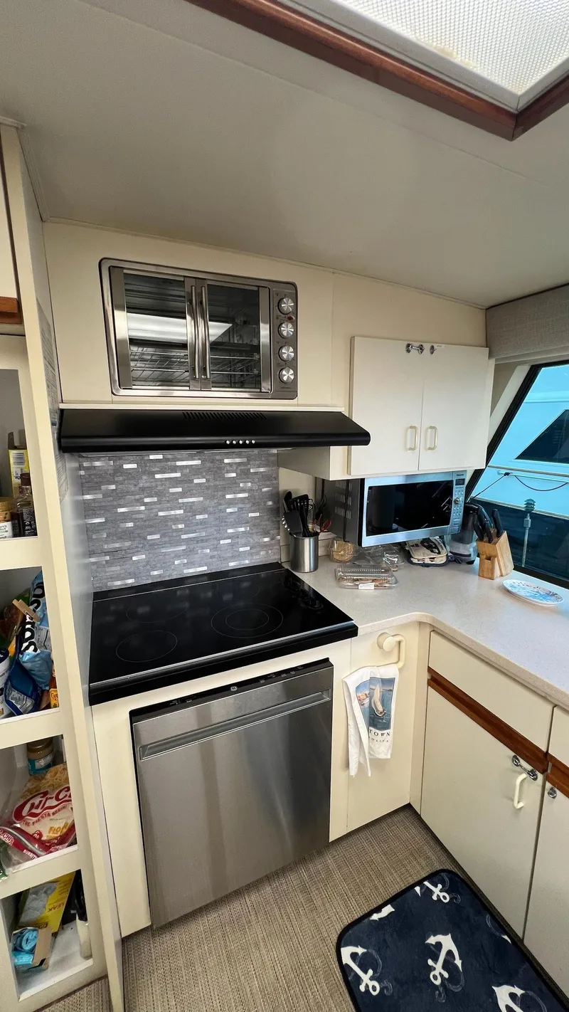 Slide: The Image of 1987 Hatteras Motoryacht kitchen with modern appliances and nautical decor. - 27