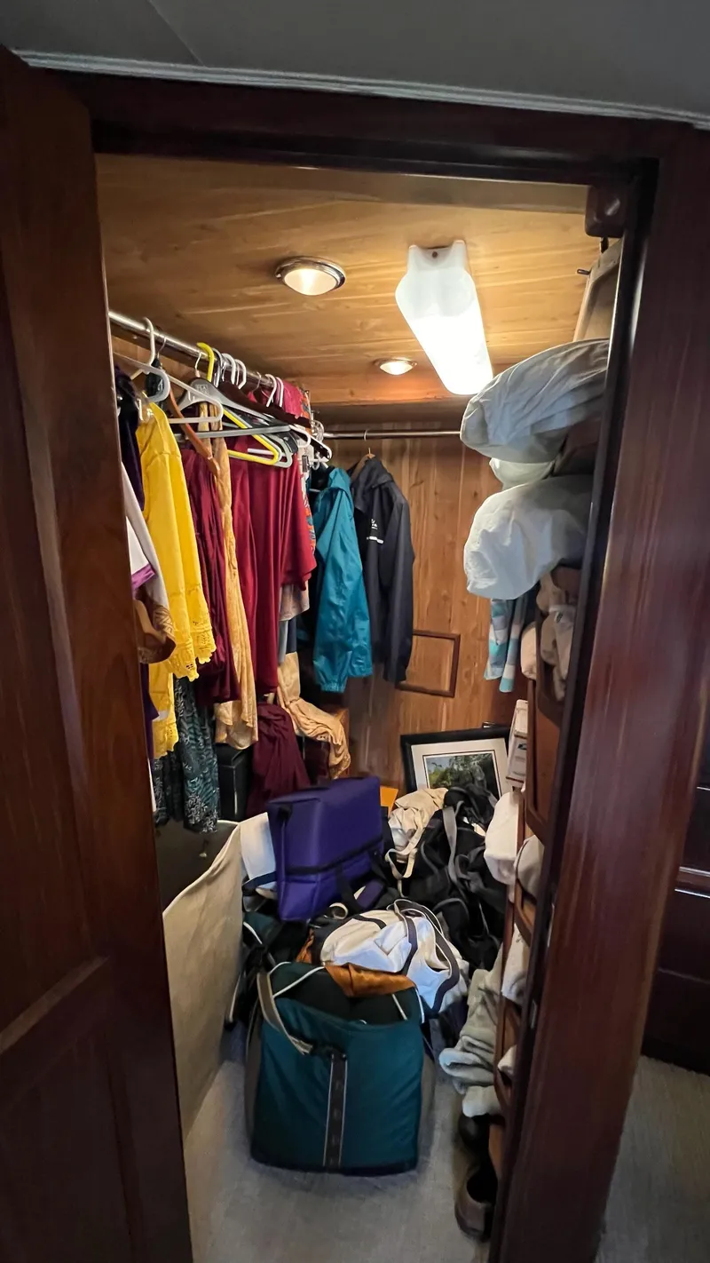 Slide: The Image of Closet interior on 1987 Hatteras Motoryacht with clothes and storage items. - 33