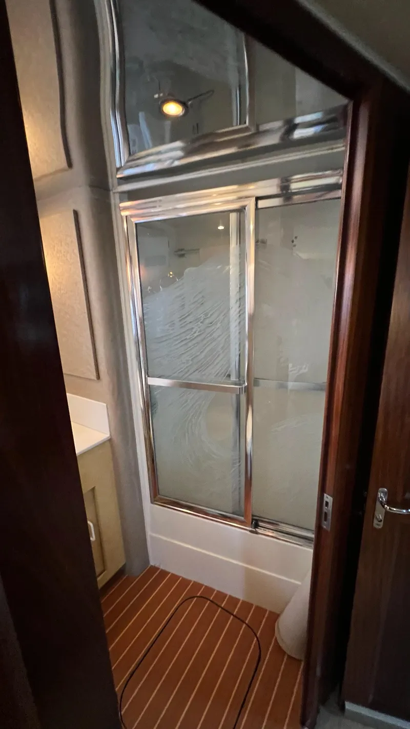 Slide: The Image of 1987 Hatteras Motoryacht bathroom with glass shower doors and wooden flooring. - 34