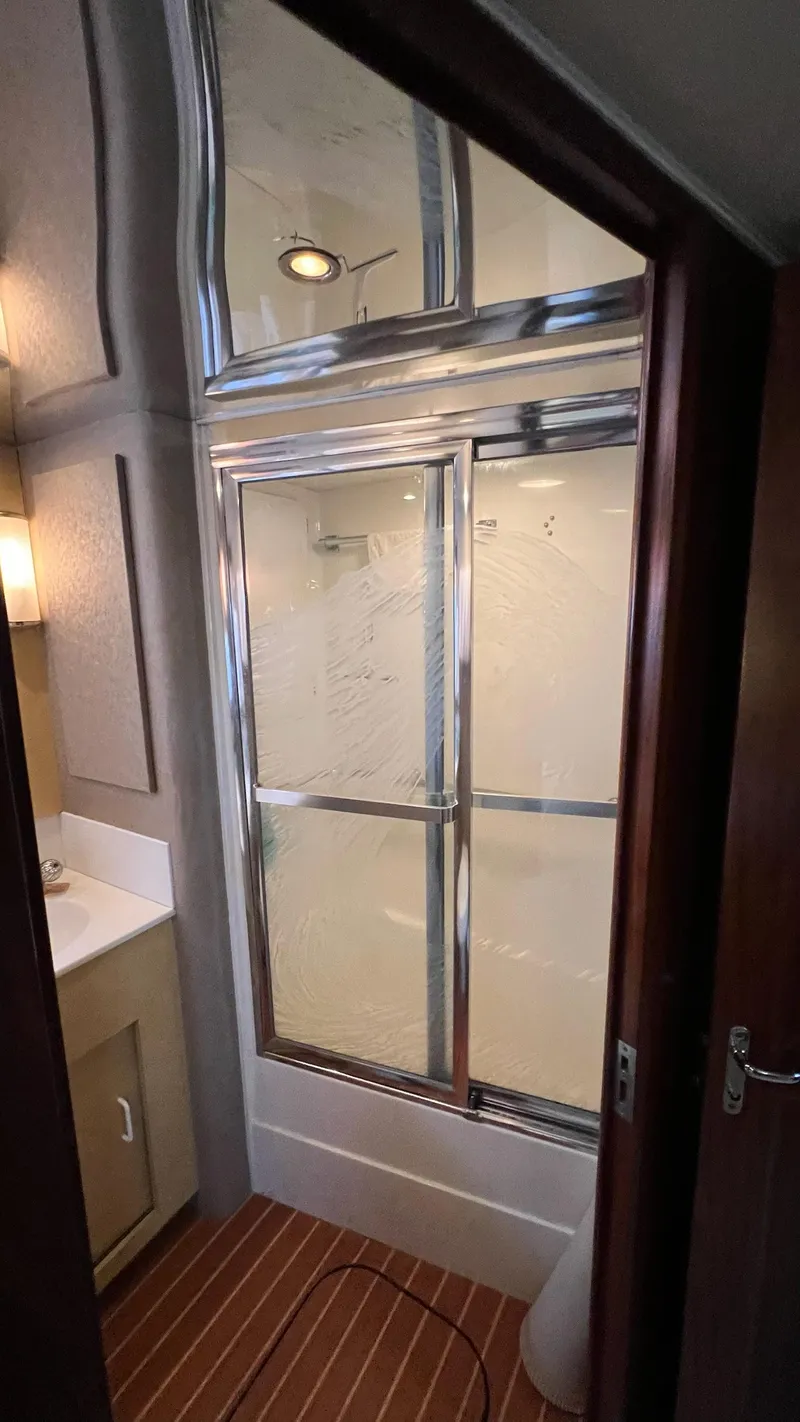 Slide: The Image of Bathroom interior of a 1987 Hatteras Motoryacht with shower and wooden flooring. - 36