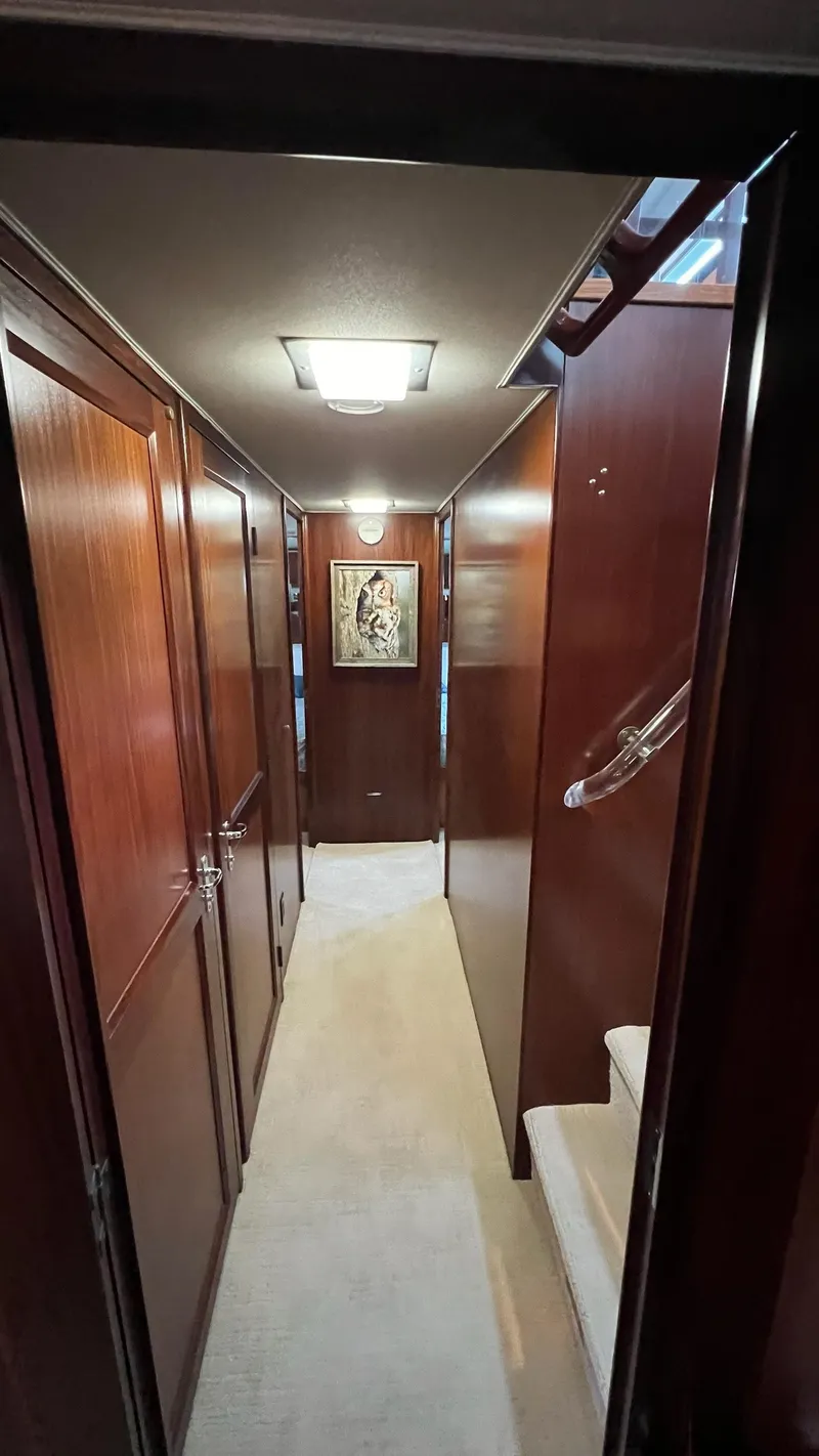 Slide: The Image of Interior hallway of a 1987 Hatteras Motoryacht with wood paneling and artwork. - 37