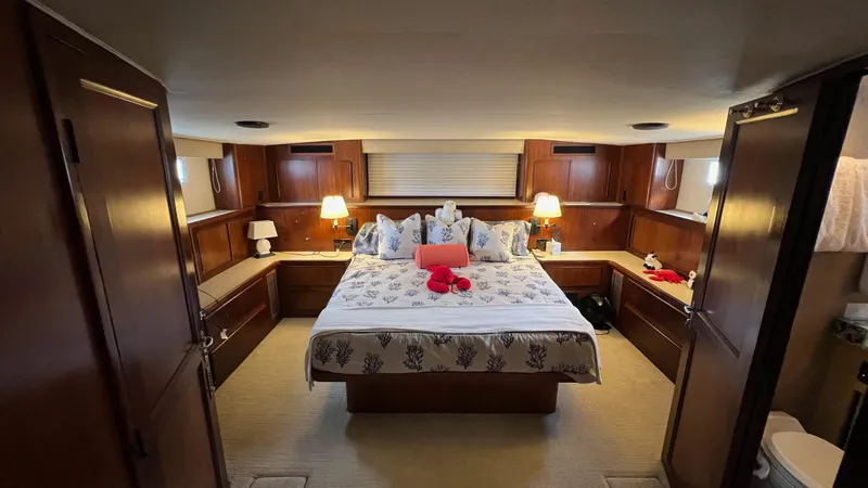 Slide: The Image of Luxurious 1987 Hatteras Motoryacht bedroom with elegant wood paneling and cozy lighting. - 4