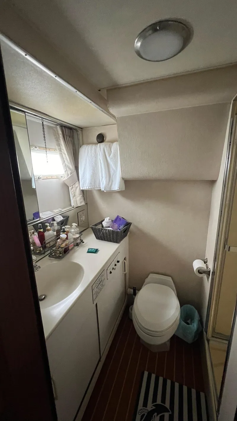 Slide: The Image of 1987 Hatteras Motoryacht bathroom with sink, toilet, and shower, featuring compact design and modern amenities. - 42
