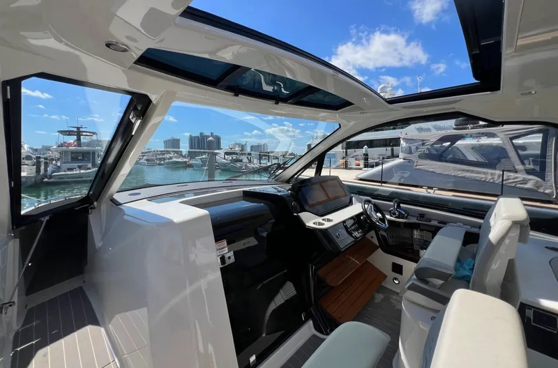 Slide: The Image of 2023 Sea Ray Sundancer 370 OB cockpit with modern helm, marina view. - 18