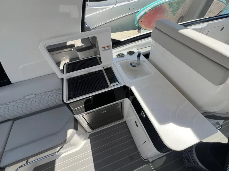 Slide: The Image of 2023 Sea Ray Sundancer 370 OB boat interior with kitchenette and seating area. - 24