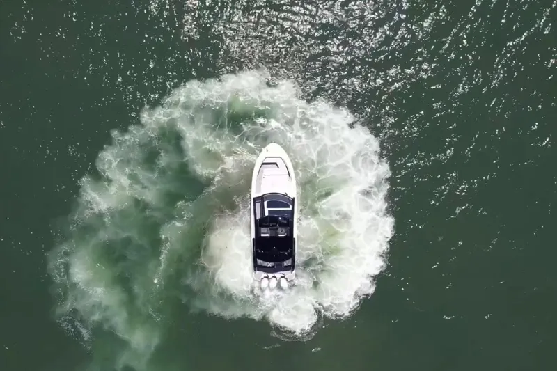 Slide: The Image of Aerial view of 2023 Sea Ray Sundancer 370 OB making a sharp turn in water. - 5