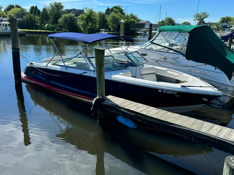 The Image of 2015 Cobalt A28 boat docked in a marina with blue canopy. - 0