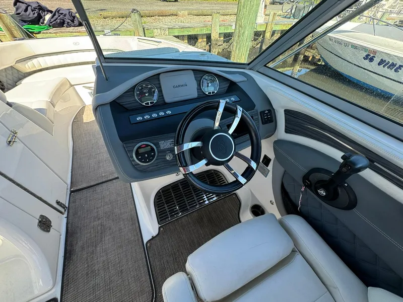 Slide: The Image of 2015 Cobalt A28 boat interior, featuring a modern helm with a sleek steering wheel. - 12