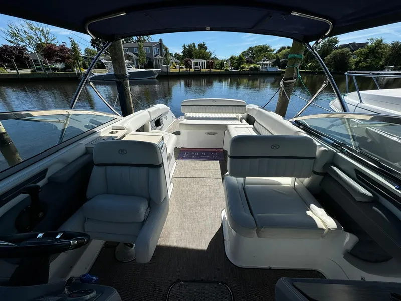 Slide: The Image of 2015 Cobalt A28 boat interior with luxurious seating on a calm waterfront. - 17