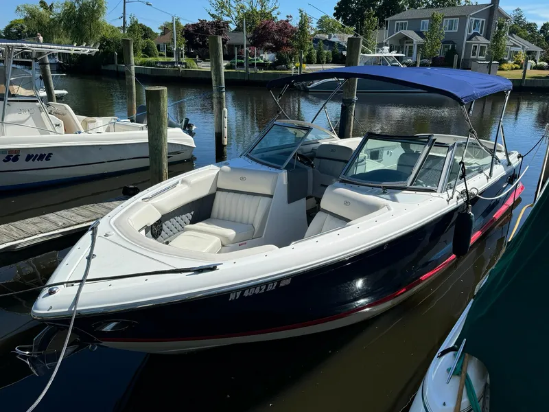 Slide: The Image of 2015 Cobalt A28 boat docked in a marina with a blue canopy. - 2