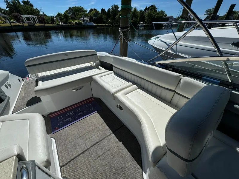 Slide: The Image of 2015 Cobalt A28 boat with white leather seating, docked by a serene waterfront. - 9