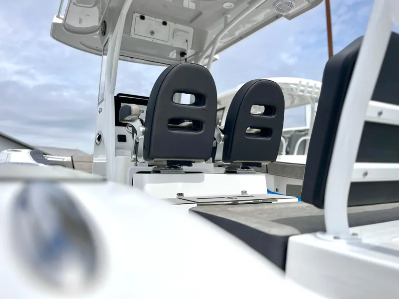 Slide: The Image of 2024 Sea Pro 245 FLX boat interior with dual black seats and white console. - 13