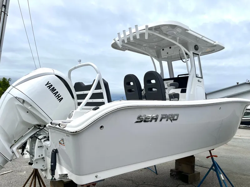 Slide: The Image of 2024 Sea Pro 245 FLX boat with Yamaha engine, white exterior, docked on stands. - 2