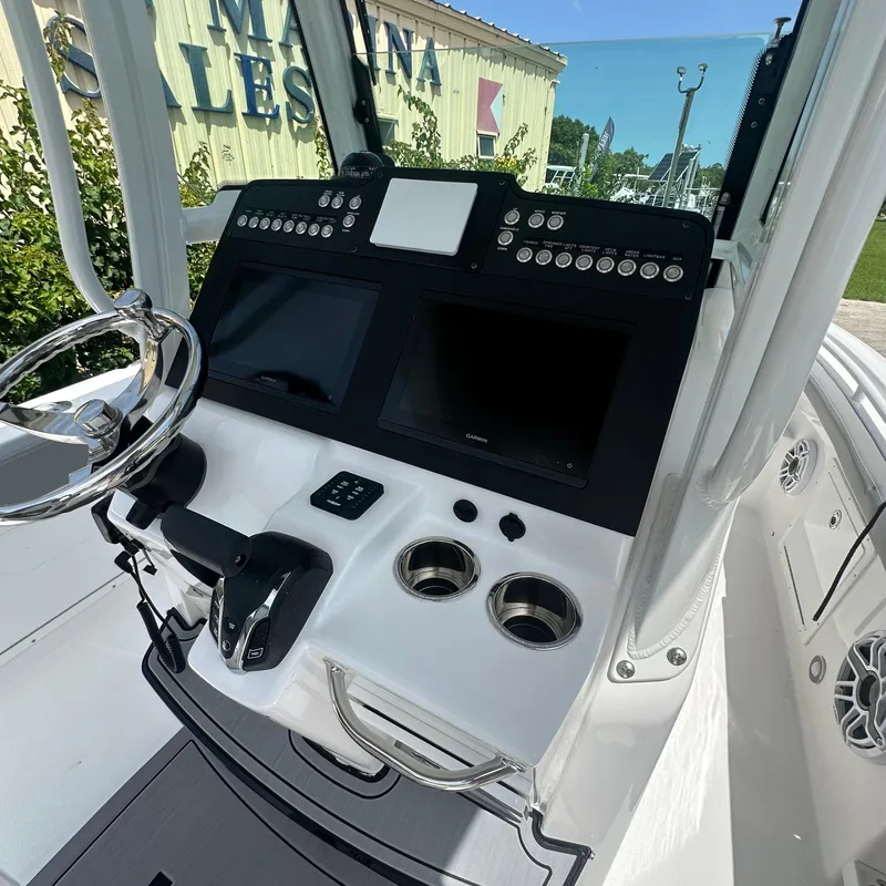 Slide: The Image of 2024 Everglades 235 Center Console boat dashboard with dual screens and steering wheel. - 5