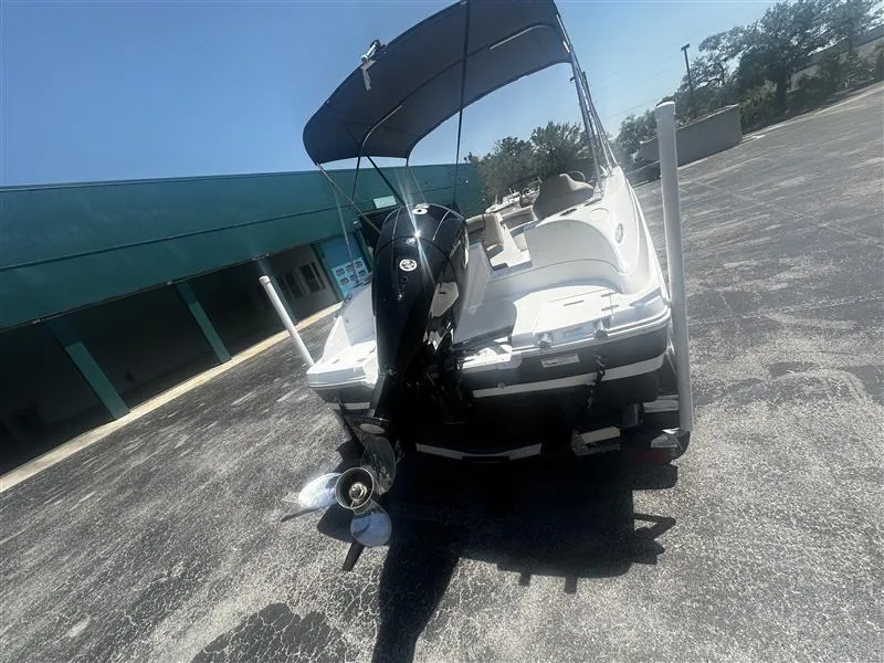 Slide: The Image of 2021 Hurricane SunDeck Sport 192 RL OB boat with outboard motor and canopy, parked outdoors. - 4