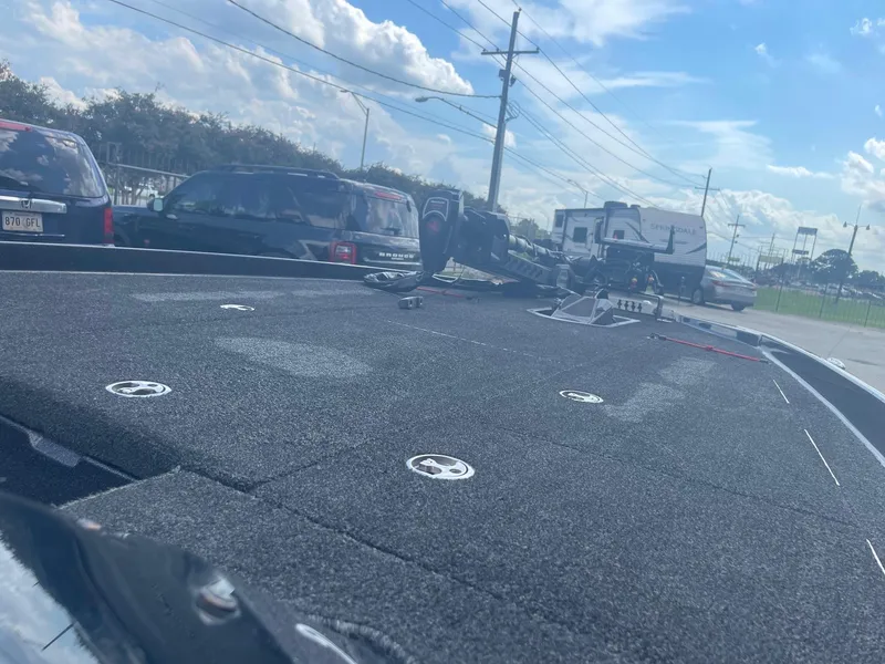 Slide: The Image of 2013 Bullet 21 XRS boat deck with equipment, parked near vehicles and trailers. - 14