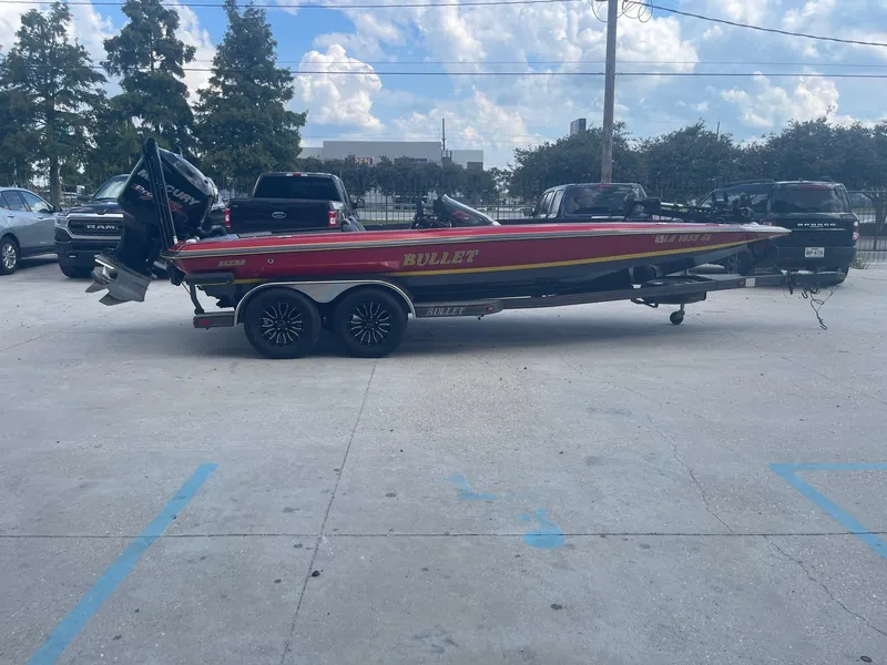 Slide: The Image of 2013 Bullet 21 XRS red and black bass boat on trailer in parking lot. - 5