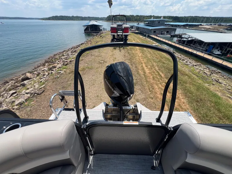 Slide: The Image of 2024 Premier 230 Sunsation RE pontoon boat with outboard motor, docked by a scenic lake. - 10