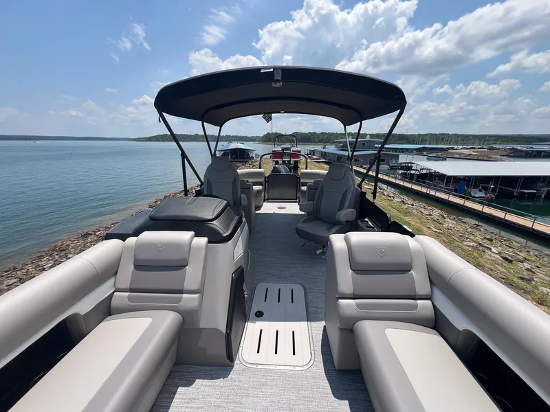 Slide: The Image of 2024 Premier 230 Sunsation RE pontoon boat with spacious seating and canopy on a sunny day. - 6