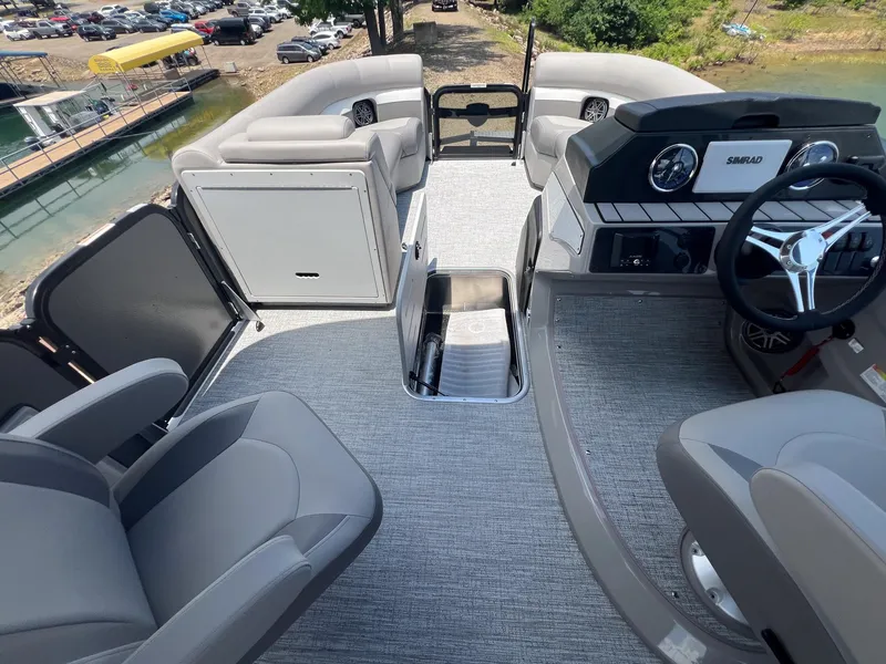 Slide: The Image of 2024 Premier 230 Sunsation RE pontoon boat interior with helm, seating, and storage. - 7