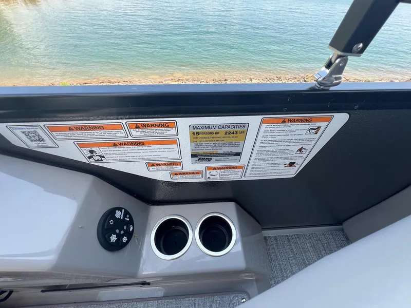 Slide: The Image of 2024 Premier 230 Sunsation RE boat interior with warning labels and cup holders. - 8