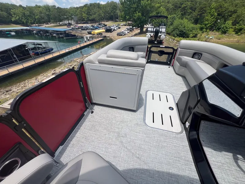 Slide: The Image of 2024 Premier 250 SunSation RF pontoon boat interior with gray seating and red accents. - 10