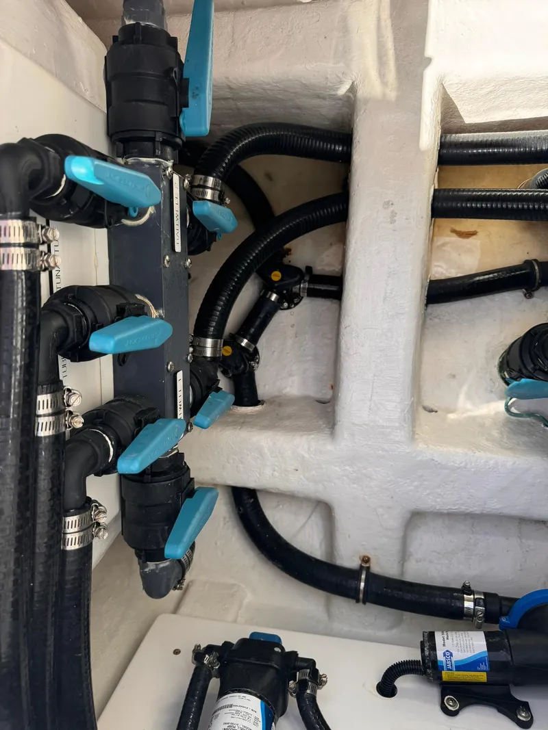 Slide: The Image of Engine room of 2022 Invincible 46 Catamaran with hoses and valves. - 18