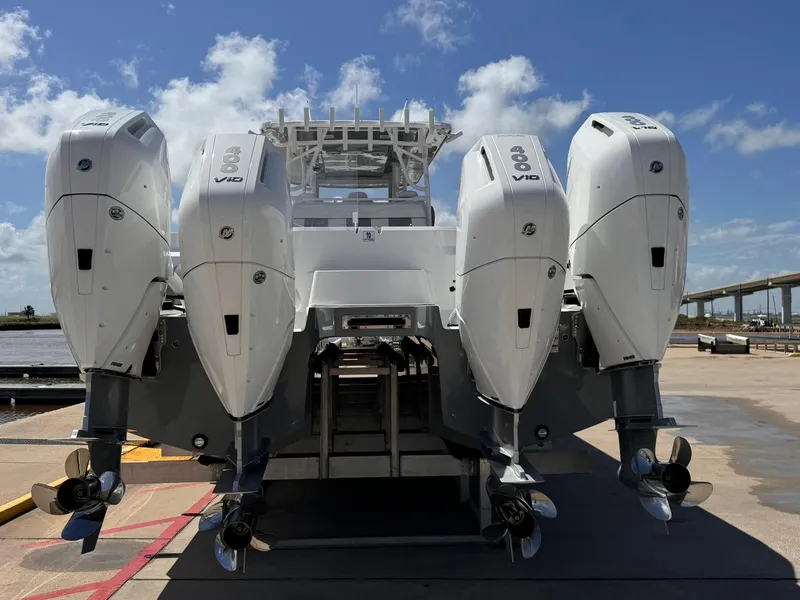 Slide: The Image of 2022 Invincible 46 Catamaran with four powerful outboard engines docked under a clear sky. - 4