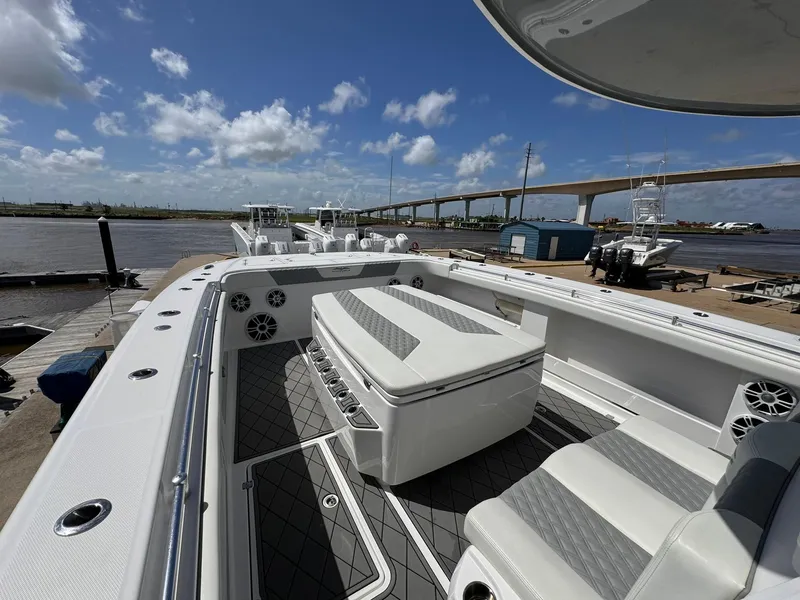Slide: The Image of 2022 Invincible 46 Catamaran docked, showcasing spacious deck and seating under clear skies. - 6