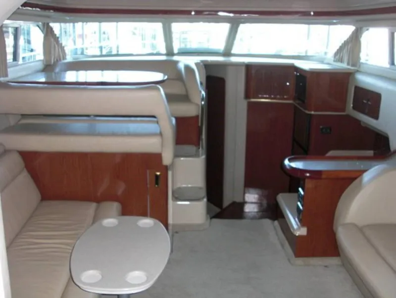 Slide: The Image of Interior of 2002 Sea Ray 400 Sedan Bridge yacht with beige seating and wooden accents. - 2