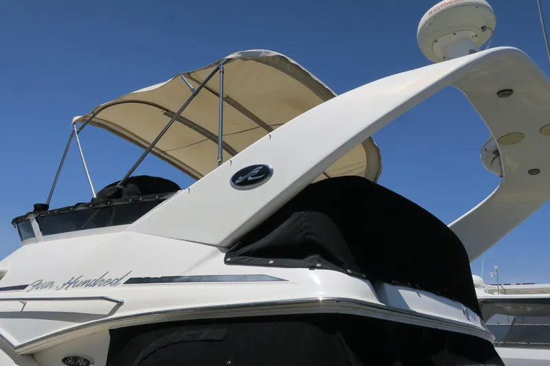 Slide: The Image of 2002 Sea Ray 400 Sedan Bridge yacht with canopy against clear blue sky. - 24