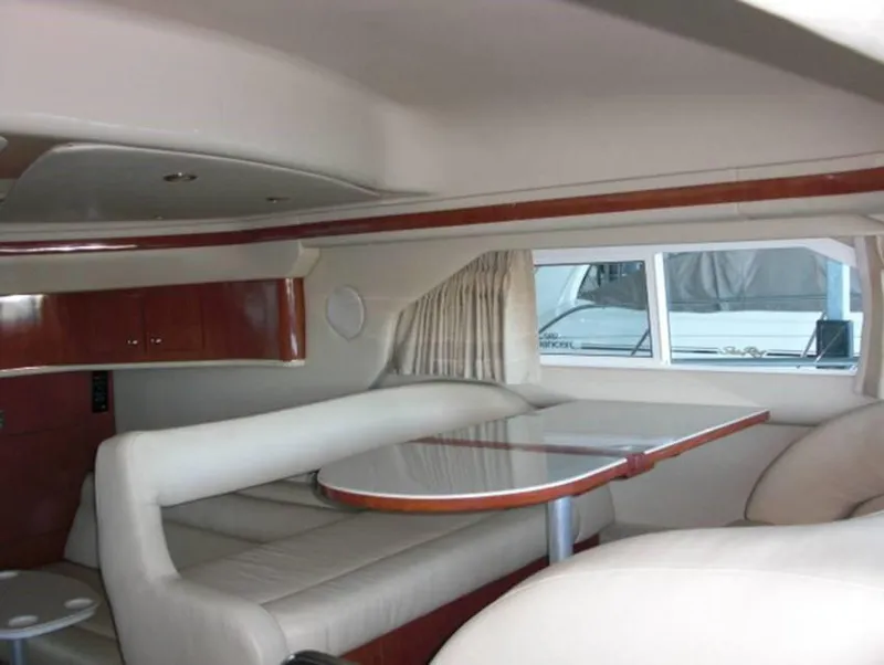 Slide: The Image of Interior of 2002 Sea Ray 400 Sedan Bridge with dining area and window view. - 3