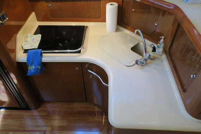 Slide: The Image of Compact kitchen area in a 2002 Sea Ray 400 Sedan Bridge yacht with stove and sink. - 47