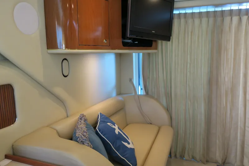 Slide: The Image of Interior of 2002 Sea Ray 400 Sedan Bridge with sofa, TV, and nautical-themed pillows. - 48