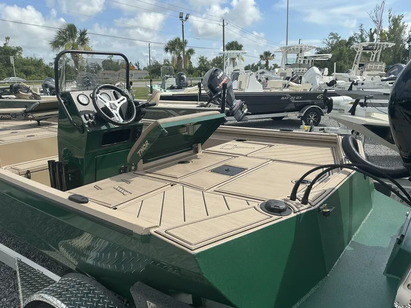 Slide: The Image of 2025 Thor LAKE HAMMER 1900 CC boat with green exterior and beige deck, parked in a marina. - 10