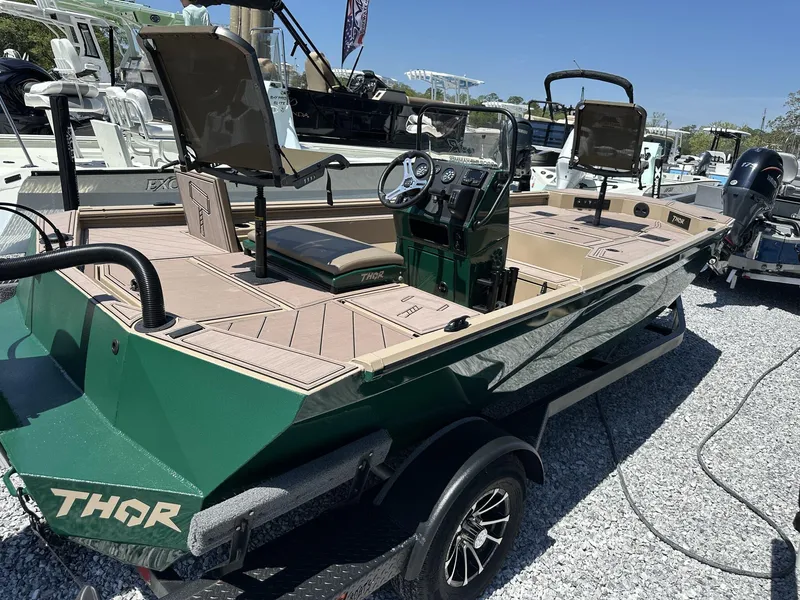 Slide: The Image of 2025 Thor LAKE HAMMER 1900 CC boat, green exterior, parked on gravel, featuring modern seating and controls. - 3