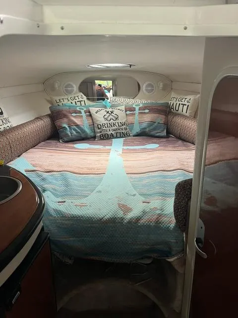 Slide: The Image of 2003 Monterey 298 SC Cruiser cabin with cozy bed and nautical-themed decor. - 6