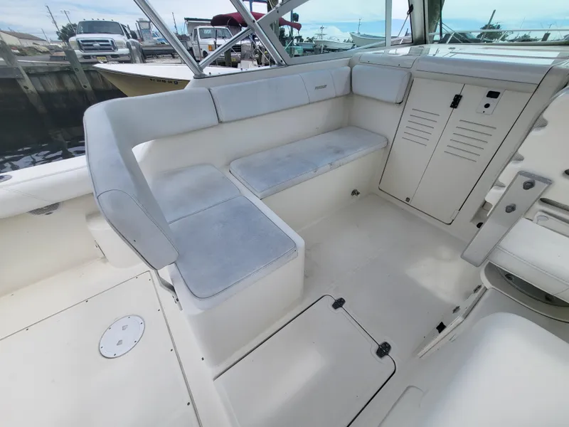 Slide: The Image of 2001 Pursuit 2860 Denali boat interior with cushioned seating and storage compartments. - 11
