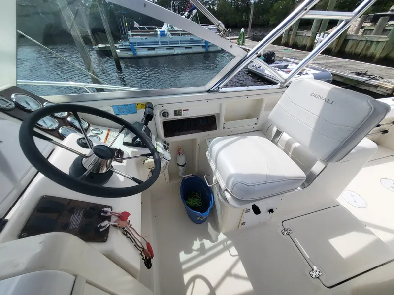 Slide: The Image of 2001 Pursuit 2860 Denali boat cockpit with steering wheel and captain's chair. - 13