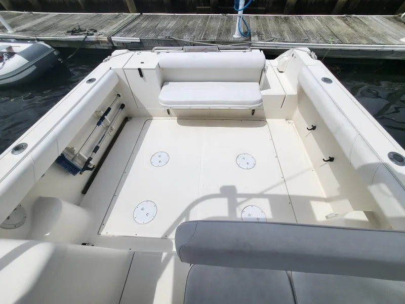 Slide: The Image of 2001 Pursuit 2860 Denali boat interior with spacious seating and clean deck at dock. - 14