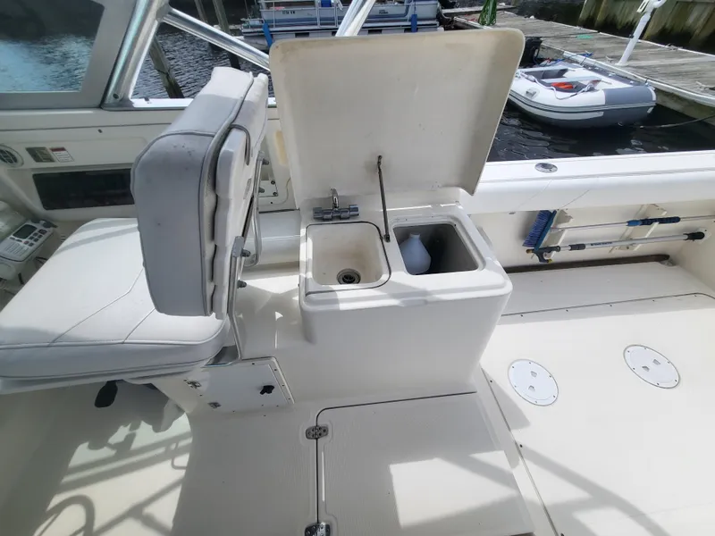 Slide: The Image of 2001 Pursuit 2860 Denali boat interior with open storage compartment and seating. - 15