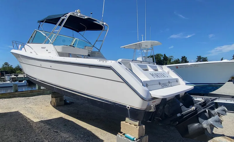 Slide: The Image of 2001 Pursuit 2860 Denali boat on blocks at marina under clear blue sky. - 18