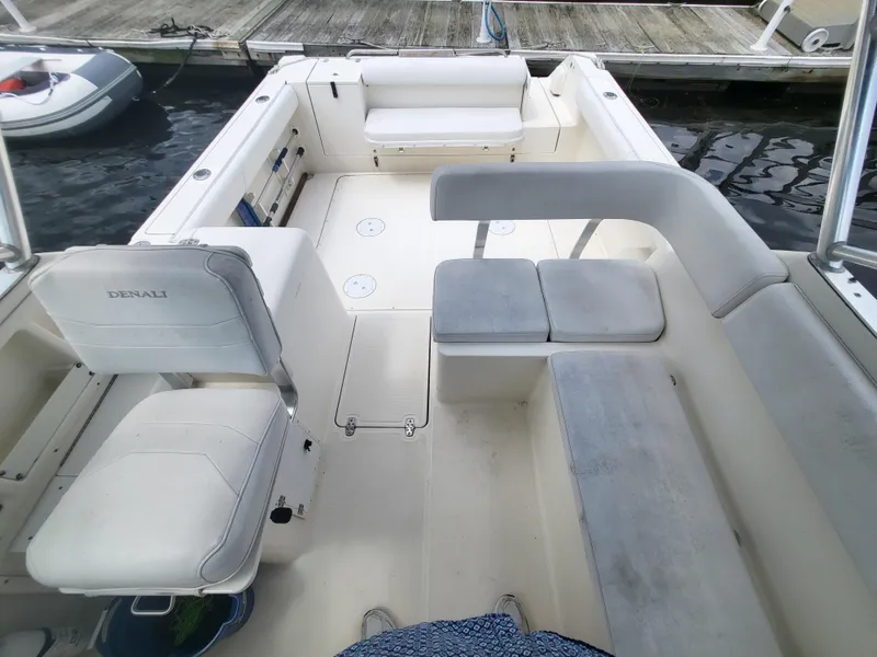 Slide: The Image of 2001 Pursuit 2860 Denali boat interior with white seating and docked at marina. - 3