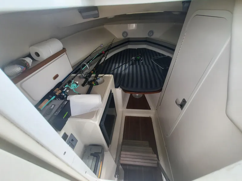 Slide: The Image of 2001 Pursuit 2860 Denali cabin interior with fishing rods and storage compartments. - 4