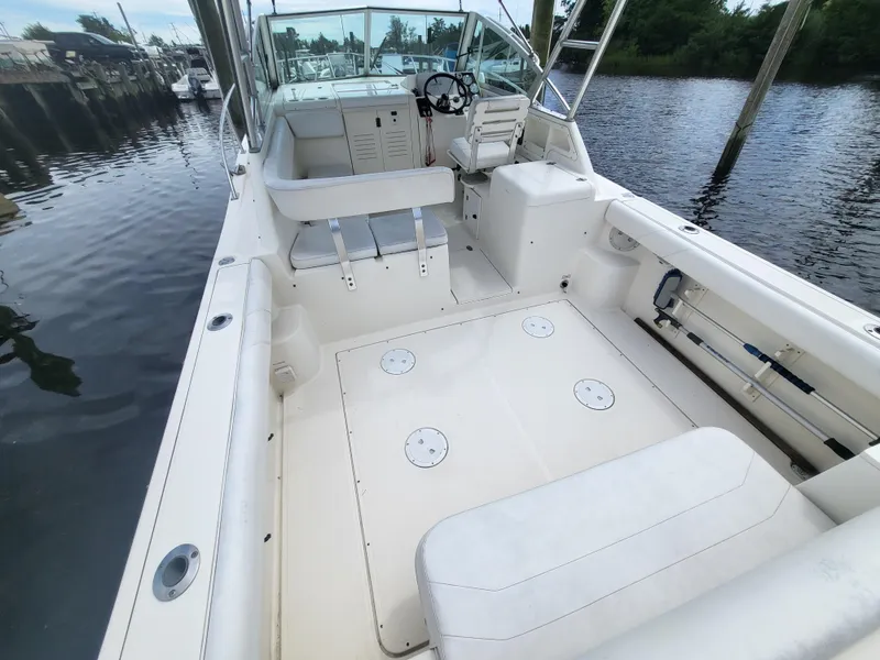 Slide: The Image of 2001 Pursuit 2860 Denali boat with spacious deck and seating, docked by the water. - 8